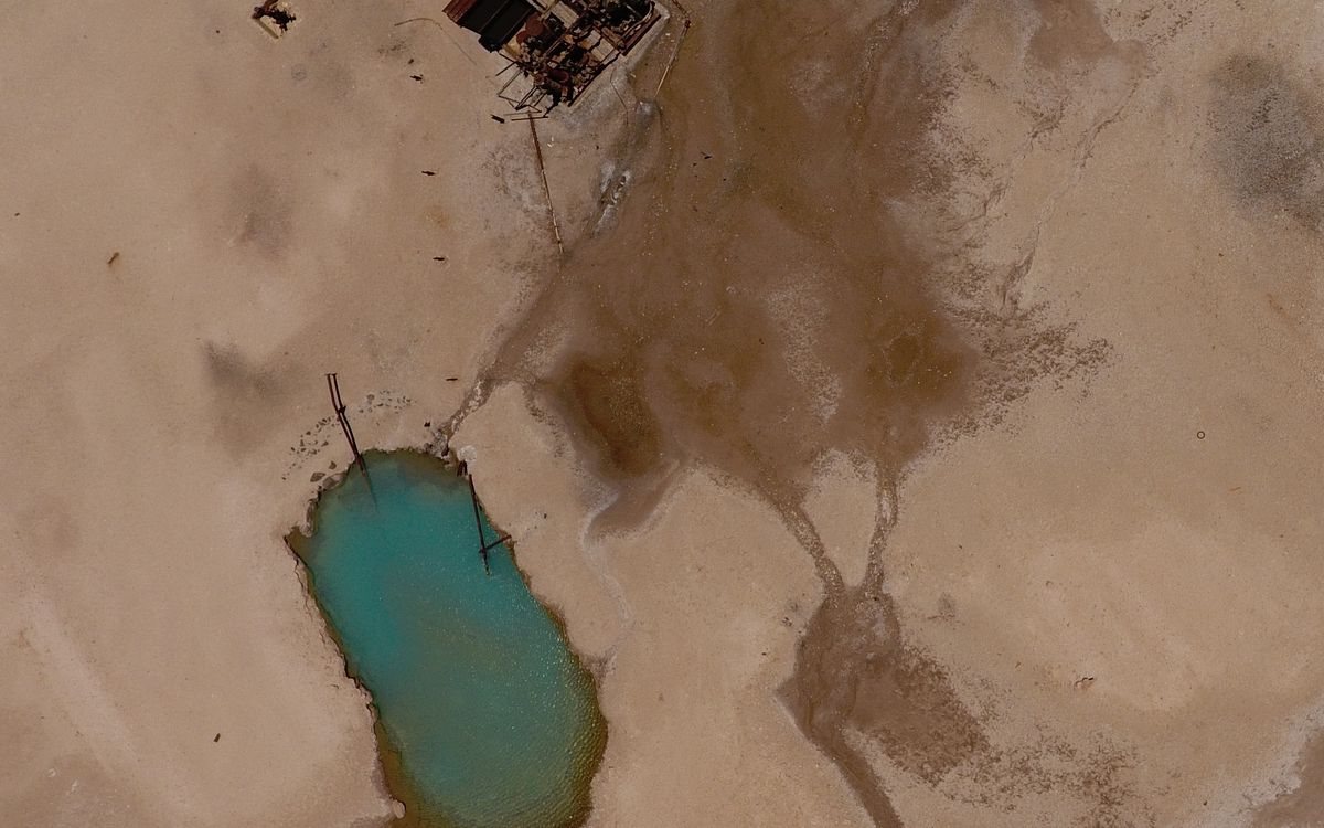 Drone view of a hot pool and outflow channels at the El Tatio geyser field, Chile