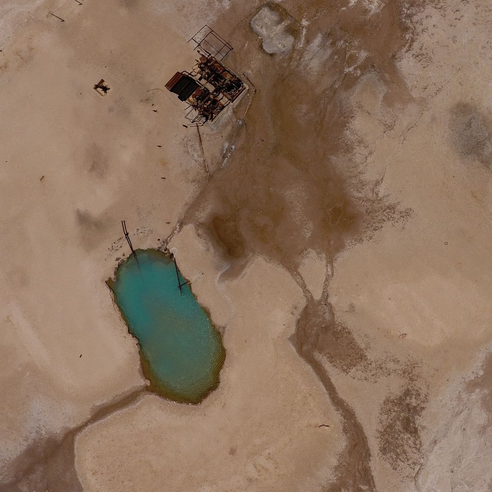 Turquoise hot pool and outflow channels seen from a drone