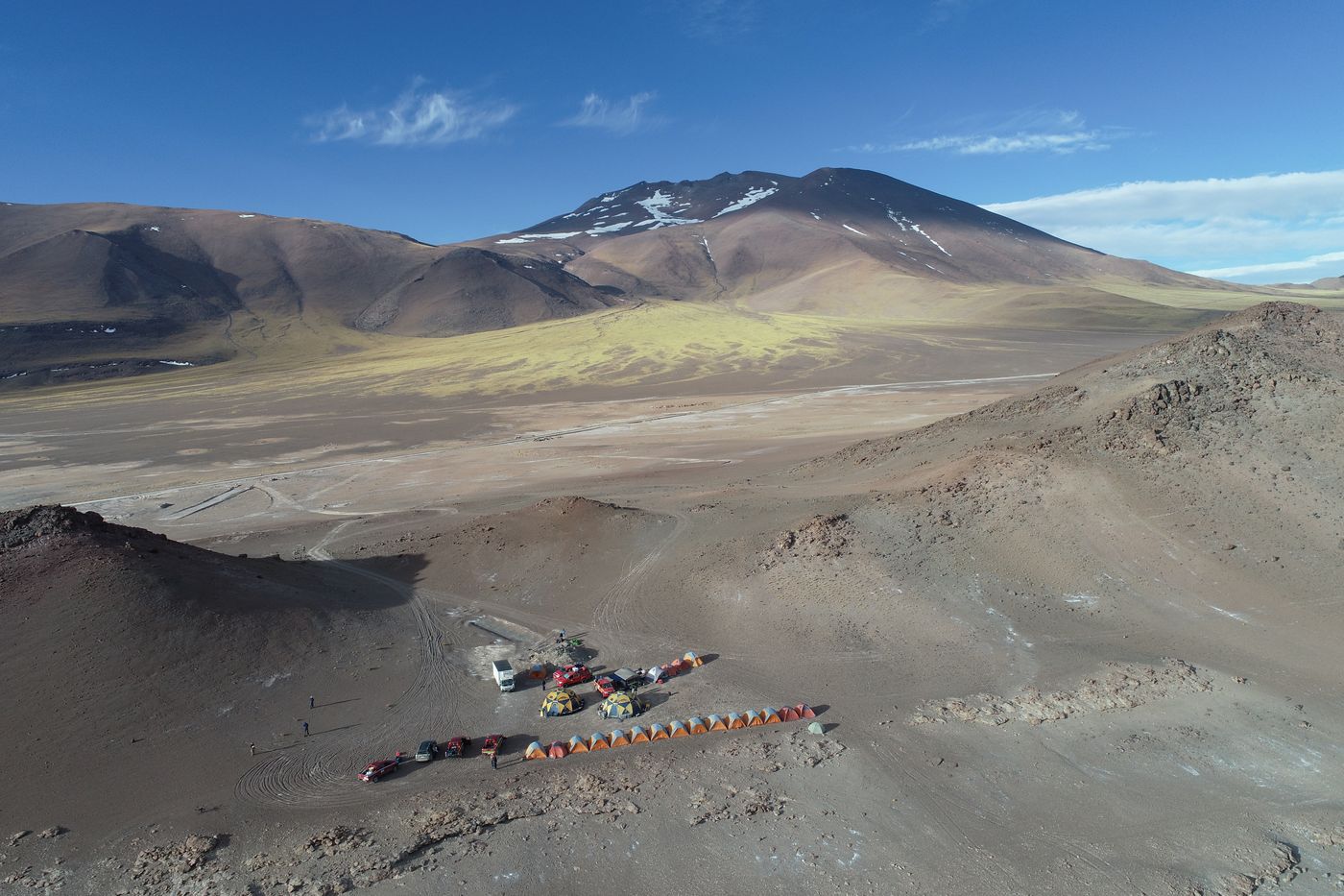 Drone view of a field camp below a volcano at Salar de Pajonales