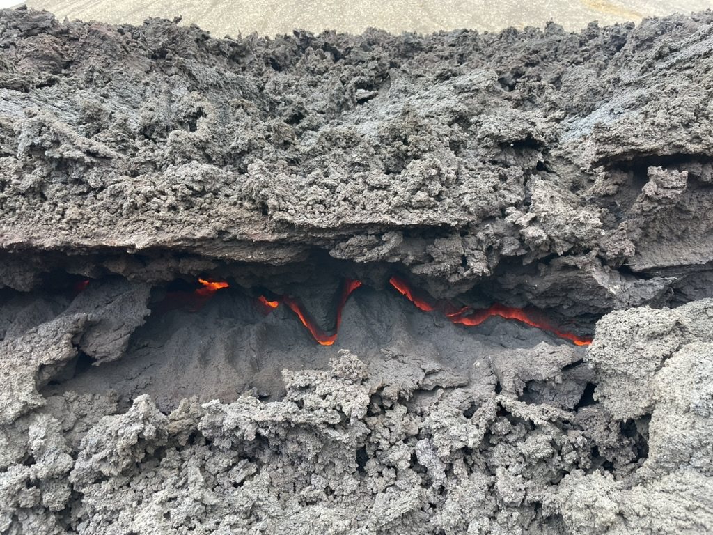 Glowing orange crack in grey fresh lava crust
