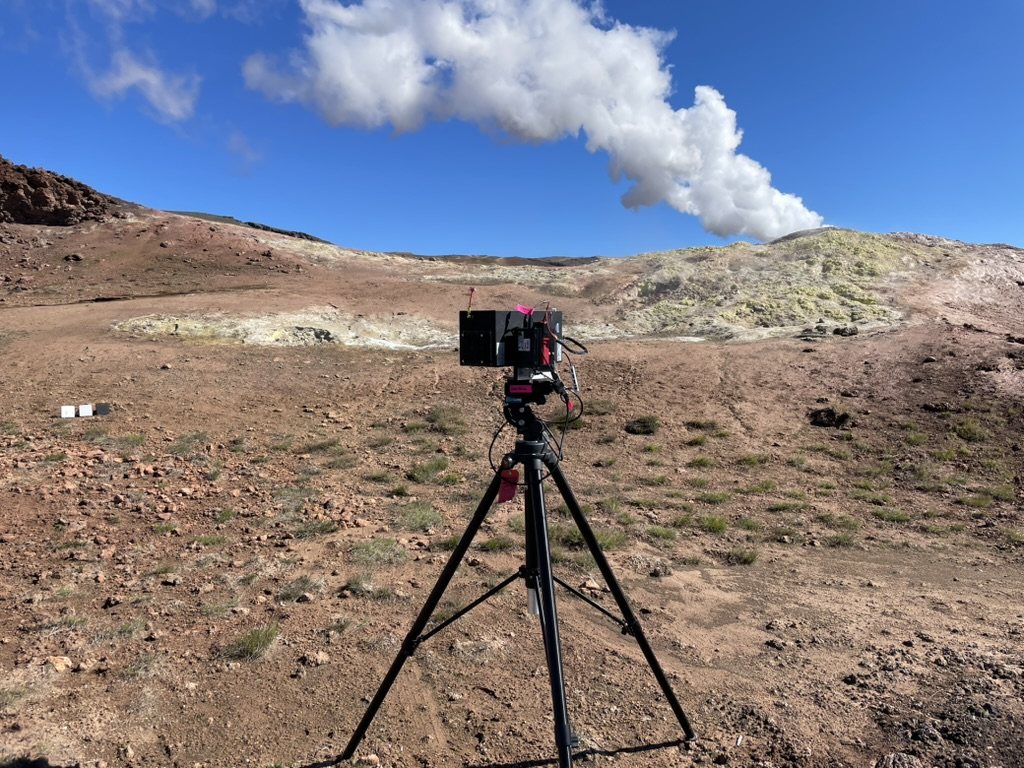 Hyperspectral camera on a tripod below a fumarole steam plume