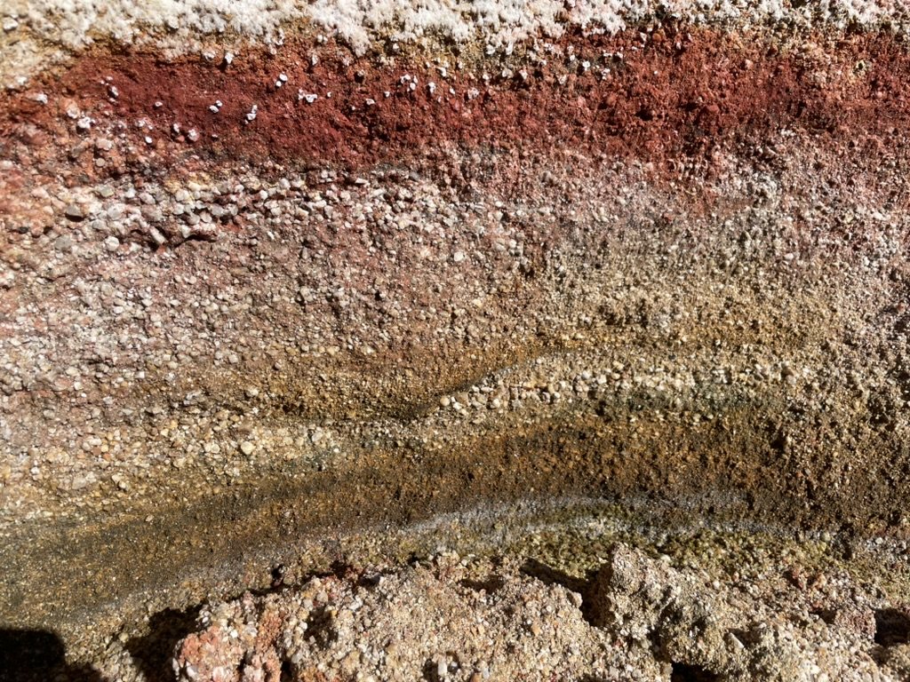 Close view of red, orange, and green banded hydrothermal deposits
